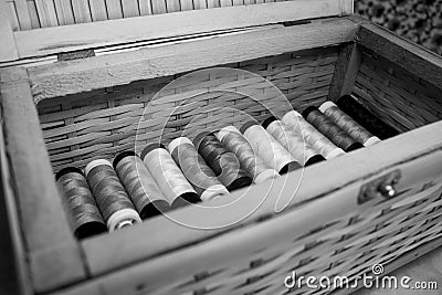 Wooden box full of thread spools multicolored [Black and White version] Stock Photo