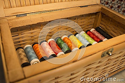Wooden box full of thread spools multicolored Stock Photo