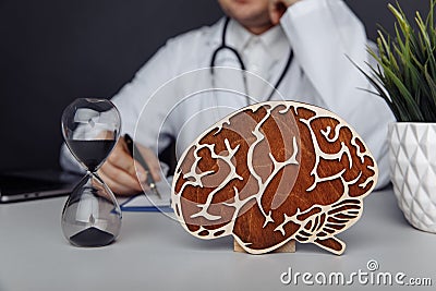 Wooden brain and hourglass in doctor& x27;s office. Dementia concept Stock Photo