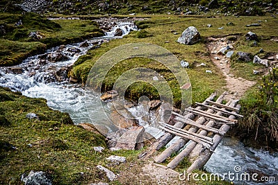 Wooden bridge across running river in the countryside Stock Photo