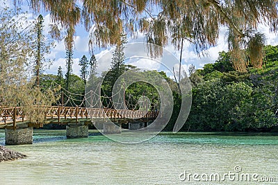 Wooden bridge across turquoise water in a tropical landscape, pines island new caledonia Stock Photo