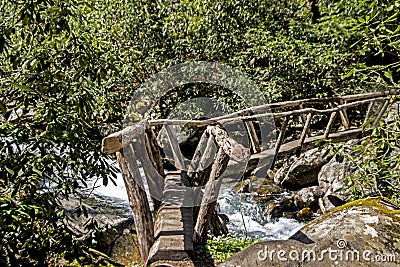 A wooden bridge crosses a creek on a hiking trail. Stock Photo