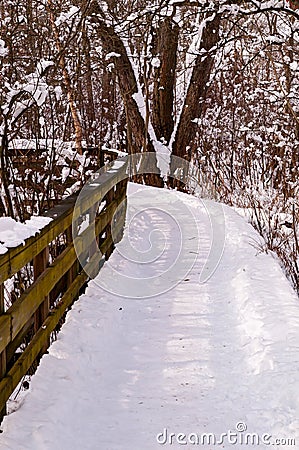 A wooden bridge on a hiking trail on a snowy winter day Stock Photo