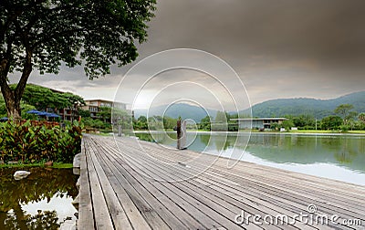 Wooden bridge at the lake in a sustainable hotel near the mountain. Luxury hotel in the forest. Green luxury hotel in the valley. Stock Photo