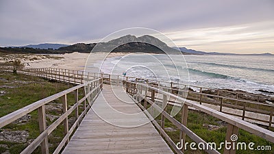 Wooden bridge leading to the Louro peak beach on a gloomy day in Galacia Spain Stock Photo
