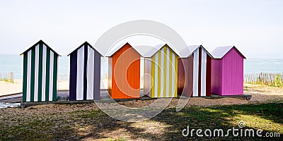 Wooden brightly coloured beach huts on West atlantic beach french in summertime Stock Photo