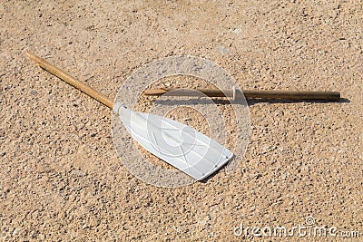 Wooden broken oar, on tan concrete, in the sun. Stock Photo