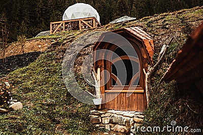 Wooden brown door to a small house on a hill on a mountain in the woods like a hobbit Stock Photo