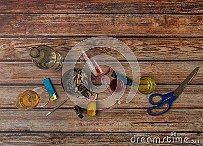 Wooden brown table with alcohol bottles and glasses and marijuana ashtray Stock Photo