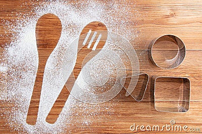 Wooden brown table dusted with flour and metal tins. Silhouette a two spoons of flour Stock Photo