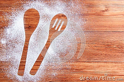 Wooden brown table dusted with flour. Silhouette two spoons in flour Stock Photo
