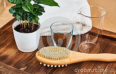 Wooden brush massage counter, washcloth for shower with double body nozzles with scrub of coffee beans in glass, towel and coffee Stock Photo