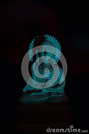 WOODEN BUDDHA STATUE IN LUMINANCE LIGHTING Stock Photo