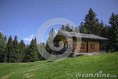 Wooden cabin house chalet in italian alps with green meadow Stock Photo