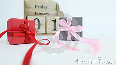 Wooden calendar with dates. Next to it is a cardboard box with a bow. Isolated on a white background. Place for your Stock Photo