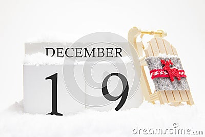 Wooden calendar for December, 19 th day of the winter month. The symbols of winter are snow and sleigh. Concept of holidays, Stock Photo