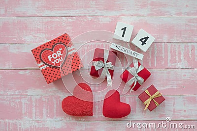 The wooden calendar, 14 February, consists of a box of red hearts written for you and hearts placed side by side with a pink Stock Photo