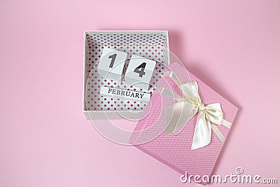Wooden calendar in the pink gift box on the pink background. Stock Photo