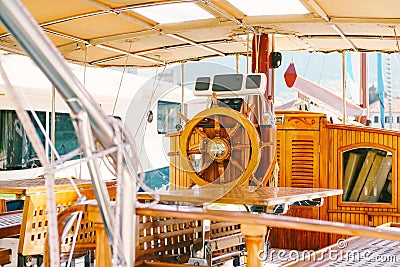 Wooden captains bridge on a white yacht with a beautiful steering wheel and folding tables Stock Photo