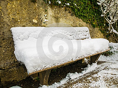 Wooden chair covered in snow in a mirabell garden.Austria Salzburg winter. Stock Photo