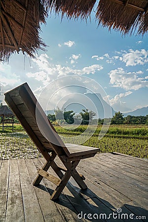Wooden chair at the homestay terrace with rice paddy view Stock Photo