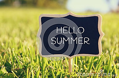 Wooden chalkboard sign with quote: HELLO SUMMER Stock Photo