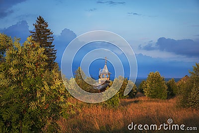 Wooden Chapel of the Kazan Icon of the Mother of God in Olkovo near Andom Mountain at sunset,.Russia, Vologda region, Vytegorsky d Stock Photo