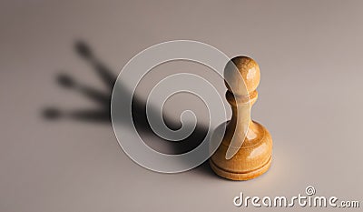 Wooden chess pawn with king shadow Stock Photo