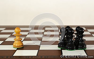 Wooden chess pieces grouped and single one Stock Photo