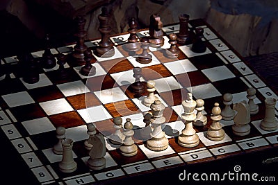 Wooden chess pieces on a wooden chessboard outdoor at the sunny Stock Photo