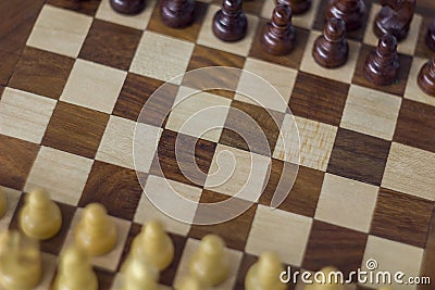 Wooden chessboard close-up with blurry pieces, top view Stock Photo