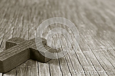 Wooden Christian cross on a rustic wooden surface, sepia toning Stock Photo