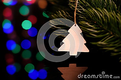 Wooden christmas toy hanging on a spruce branch. Card. Magic bright background. Reflection in black glass Stock Photo