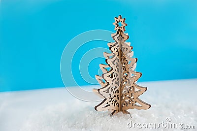 Wooden Christmas tree with artificial snow tree on blue background with copy space. Christmas tree, minimal New Year s card. Holid Stock Photo