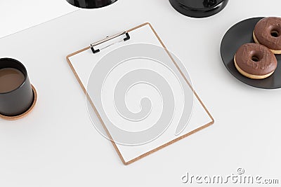 Wooden clipboard mockup with a coffee, donuts and a lamp on a white table Stock Photo