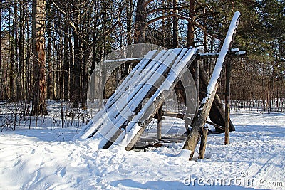 Wooden collapsed log hut in the forest in winter Stock Photo