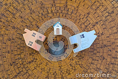 Wooden color miniature house design on ancient wooden Chinese compass background Stock Photo