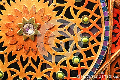 Wooden, colored, bright, mottled carved wall with flowers, stars, patterns, colored stones of different shapes and sizes and a dia Stock Photo