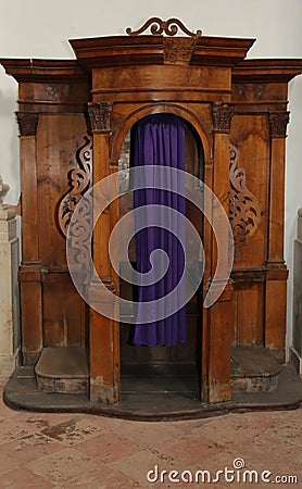 Wooden confessional inside a church with curtain Stock Photo