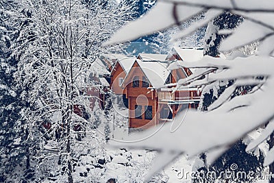 Wooden cottage holiday house in mountain holiday resort covered with fresh snow in winter Stock Photo