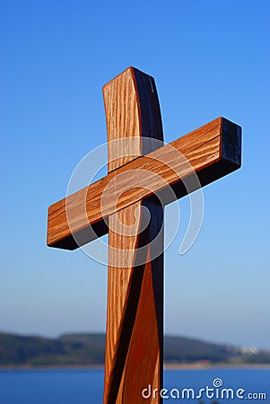 Shiny wooden cross in blue sky Easter symbol Stock Photo