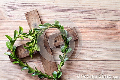 Wooden cross with sprigs of boxwood in heart-shaped, easter symbol of life, religious concept Stock Photo