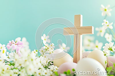 Wooden cross with spring flowers and easter eggs against tender blue background Stock Photo