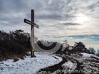 Cross standing on a snowy mountaintop Stock Photo