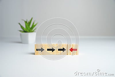 Wooden cube block with red arrow facing the opposite direction black arrows, Unique, think different, individual and Stock Photo