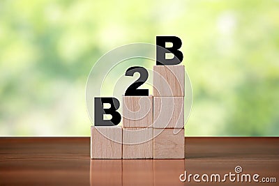 Wooden cube block shapes as step stairs with B2B Business to Business word. Business concept, success and growth Stock Photo