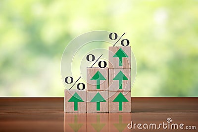 Wooden cube block shapes as step stairs with percent sign and green arrows pointing up. Business concept, success and growth Stock Photo