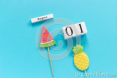 Wooden cubes calendar August 1. Summer fruits pineapple, watermelon on blue background. Concept hello August Copy space Creative Stock Photo