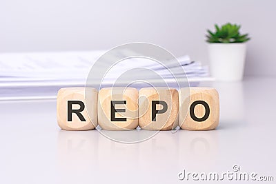 The wooden cubes displaying the text 'REPO' against a light gray background signify a focus on the repurchase Stock Photo