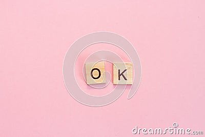 Wooden cubes inscription OK on pink background Stock Photo